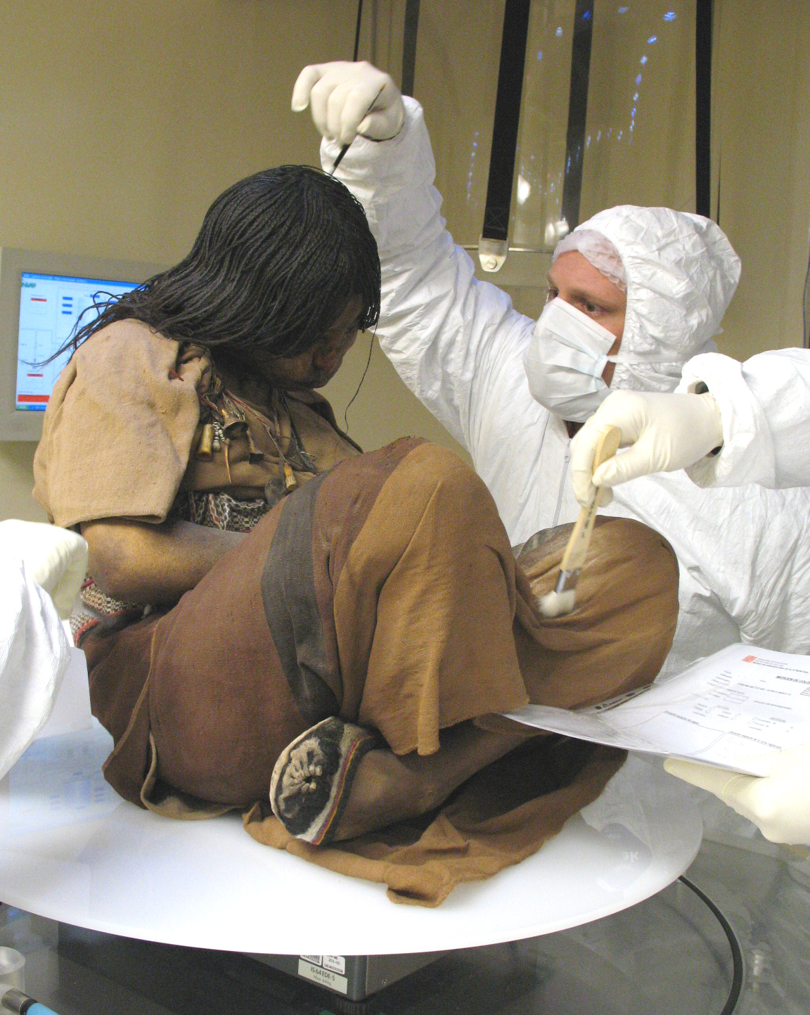 A scientist carefully extracts a hair from the sacrificial victim known as the “Llullaillaco Maiden,” a 15-year-old inhabitant of the Inca Empire