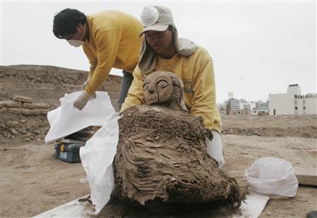 Workers removing one of Three Wari Mummies from Tomb in Lima, Peru